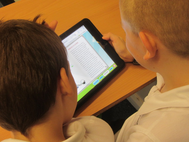 2 children looking at a tablet screen