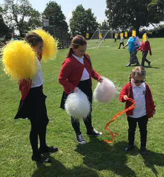 Children playing with pom poms & ribbons